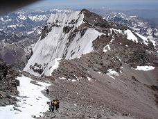 Pli da personoj de aliaj ekspedicioj supreniras. Fone, la suda pinto.